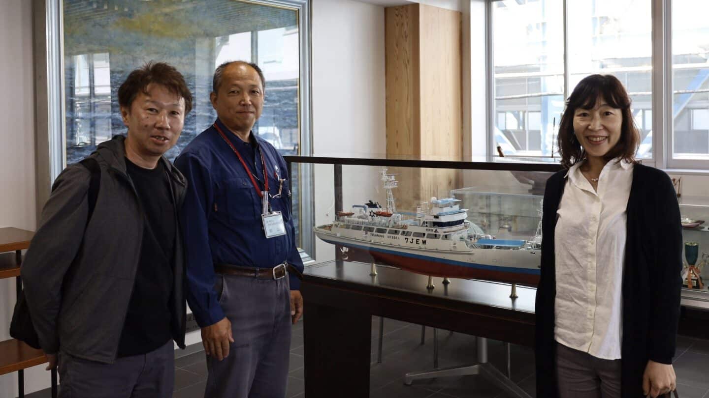 実習船の模型の前に並ぶ関係者