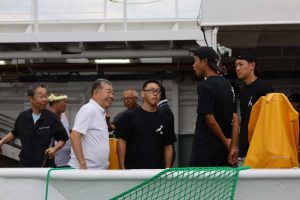 社長が新人3人を笑顔で激励している姿