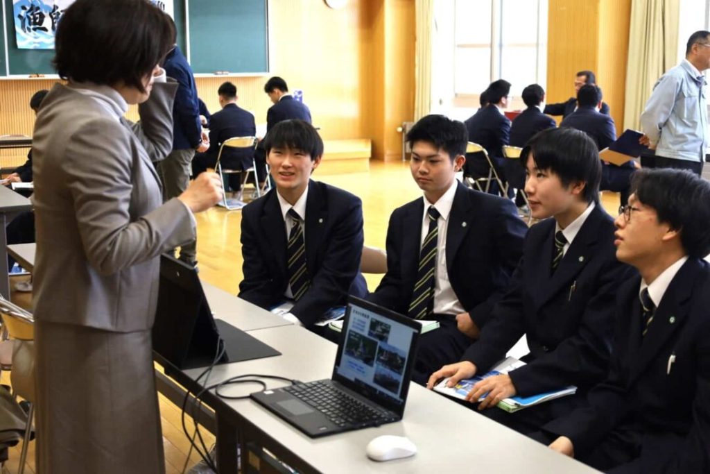 女性の話を聞く高校生