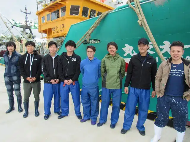 漁船の前に並ぶ若手漁業者の集合写真