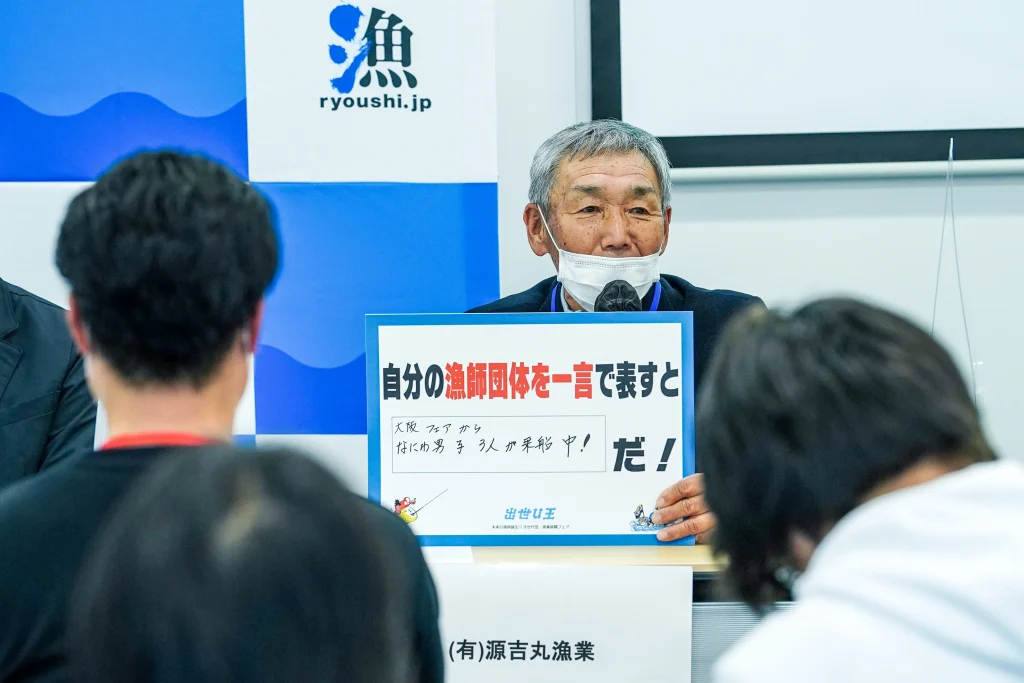 「自分の漁師団体を一言で表すと」のフリップを持って発表する（有）源吉丸漁業の男性