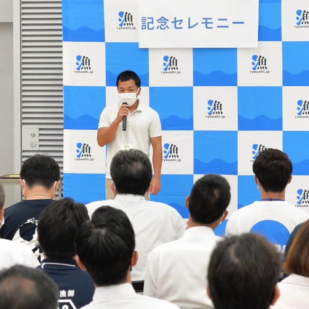 マイクを持って話す男性