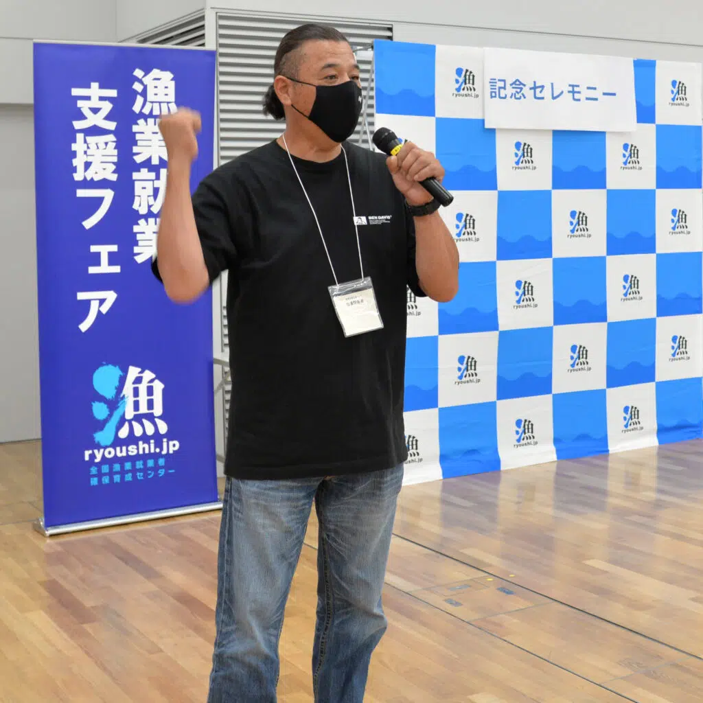マイクを持って話す男性