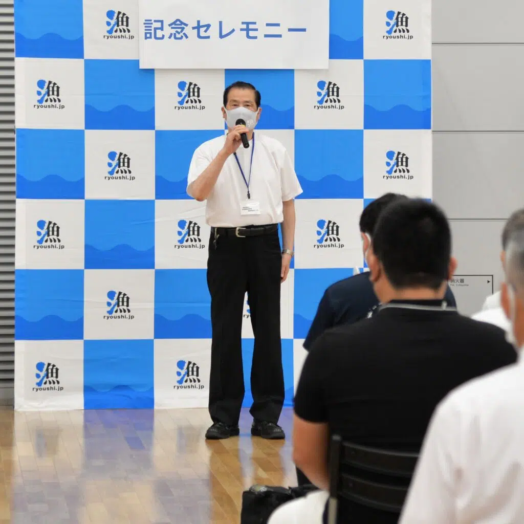 マイクを持って話す男性
